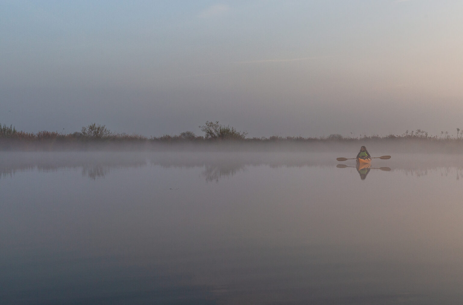 Kajakfahrer auf der Nebel-verhangenen Peene