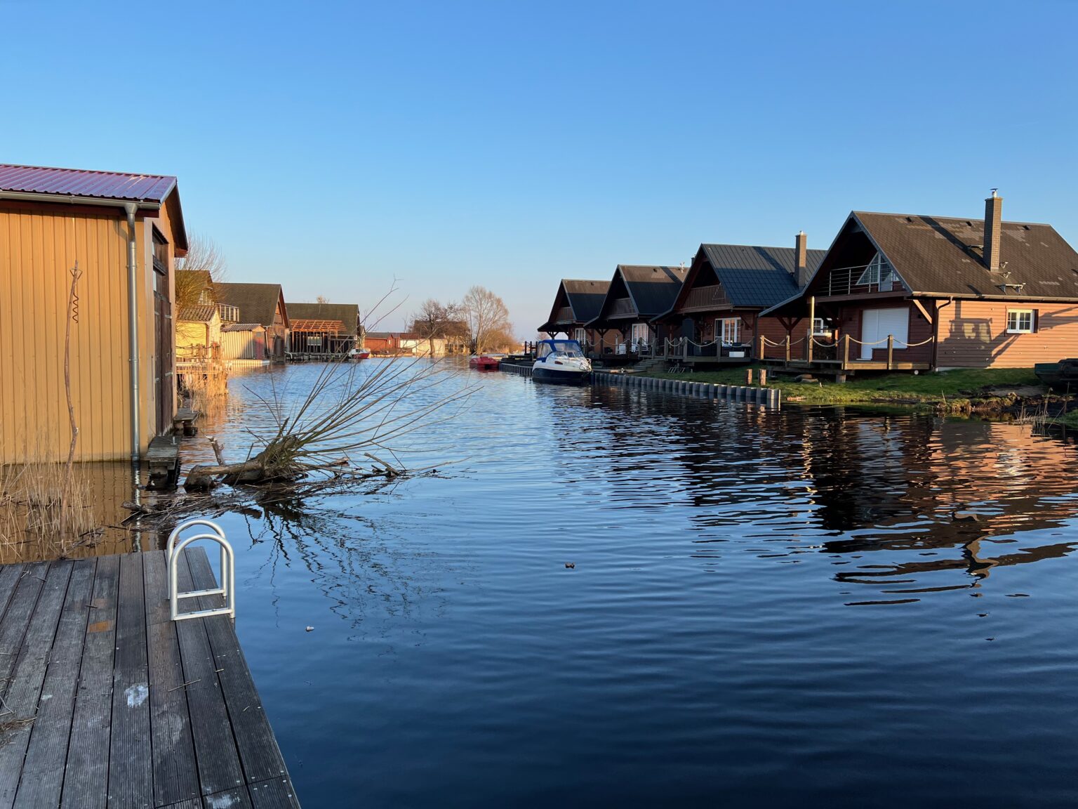 Penne bei Neukalen, Bootshäuser, Blick vom Steg des Ferienhauses